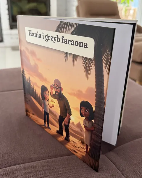 Wydrukowana książka „Hania i grzyb faraona” w twardej oprawie stoi na pufie